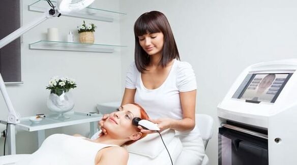 a specialist takes care of skin rejuvenation with a device